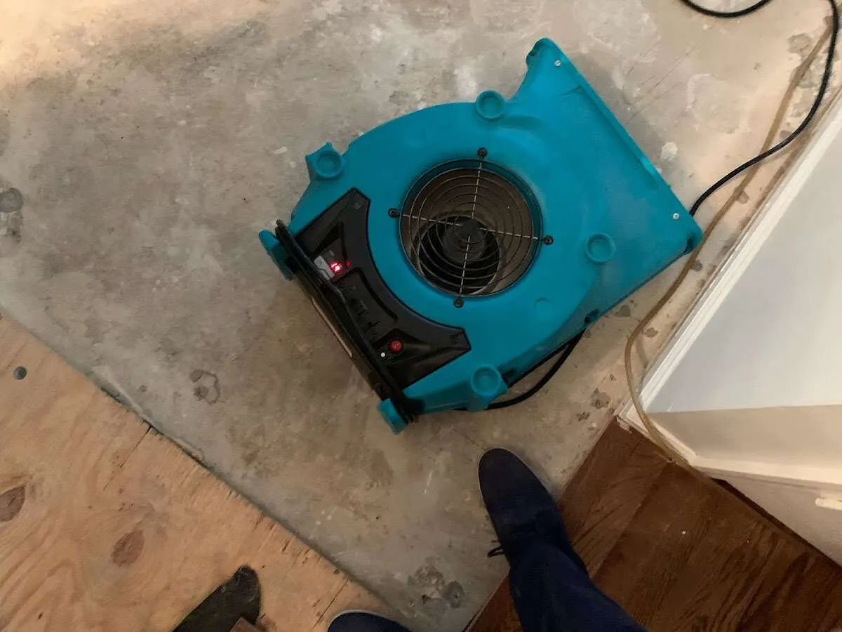 Air mover drying subfloor during Commercial Water Damage Restoration in Norman